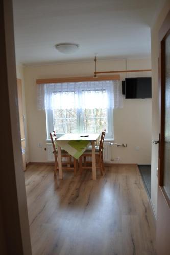 a dining room with a table and chairs and a window at Chata Eliška in Loučná nad Desnou