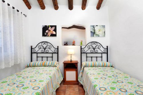 two beds sitting next to each other in a room at Cortijo Salva in Periana