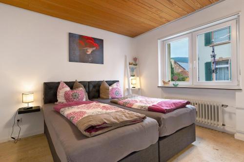 two beds in a room with a window at Fewo unter der Kirche in Herbolzheim