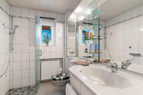 a white bathroom with a sink and a toilet at Fewo unter der Kirche in Herbolzheim