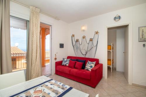 a living room with a red couch and a window at Frisaia F3 in Isola Rossa