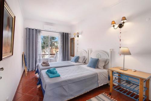 a bedroom with two beds and a table and a window at Casa Terracota in Silves