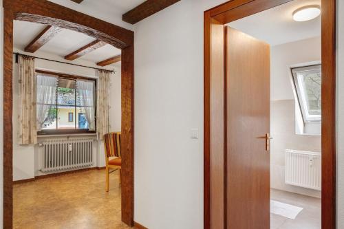 an open door to a room with a chair and a window at Bergbauernhof 1910 in Oberharmersbach