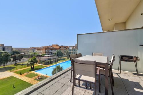 a table and chairs on a balcony with a view of a pool at Sublime Mundo Apartamento in Apúlia