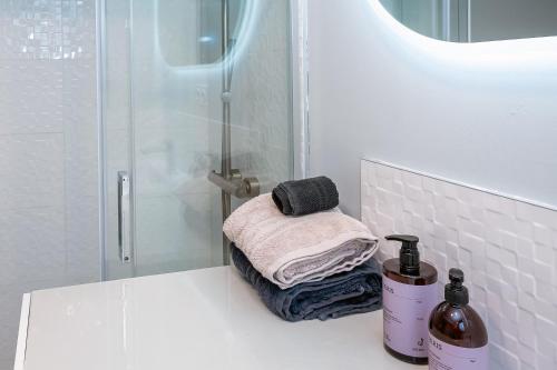 a bathroom with a shower with a stack of towels at Appart bureau in Le Touvet