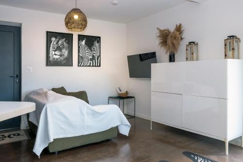 a living room with a bed and a white cabinet at Appart bureau in Le Touvet