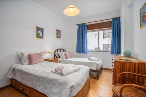a bedroom with two beds and a window at Apartamento Escadinhas in Lagos