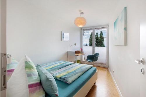 a bedroom with a bed and a desk and a window at Ferienhaus Schwalbennest in Lörrach