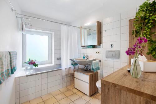a bathroom with a sink and a toilet and a window at Ferienhaus Schwalbennest in Lörrach