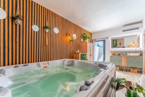 a jacuzzi tub in the middle of a room at Une parenthèse en luberon, jacuzzi in Les Taillades