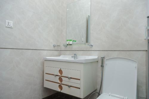 a bathroom with a sink and a toilet and a mirror at Tanga New Apartments in Tanga