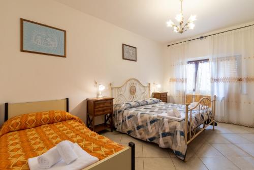 a bedroom with two beds and a table and a window at Papà Giuseppe La Cantina in Cortona