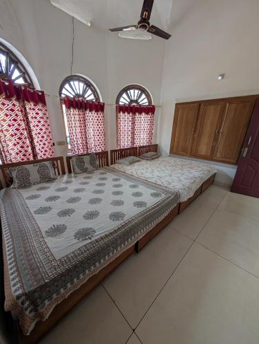 a large bed in a room with windows at Alhind Residency , Valara, Munnar in Munnar