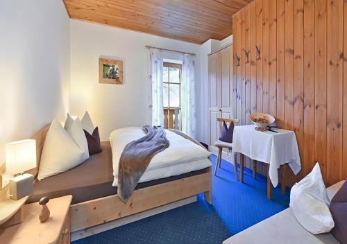 a room with two beds and a table with a table sidx sidx at Appartments Radauerhof in Castelrotto