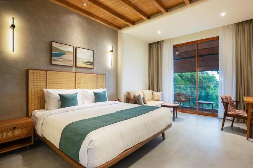 a bedroom with a large bed and a large window at Olive Woods in Chinnakanal