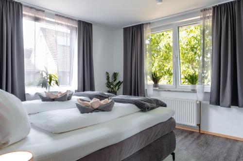 a large bed in a room with two windows at Ferienwohnung am Elbstrom in Stade