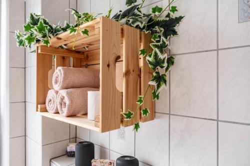 a wooden shelf on a wall with towels and plants at Ferienwohnung am Elbstrom in Stade