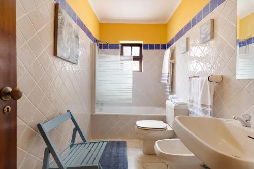 a bathroom with a toilet and a sink at Cottage Sete Mares in Colares