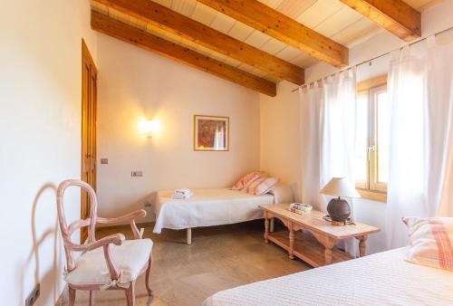 a bedroom with two beds and a table and a couch at Finca Son Fornes in Búger