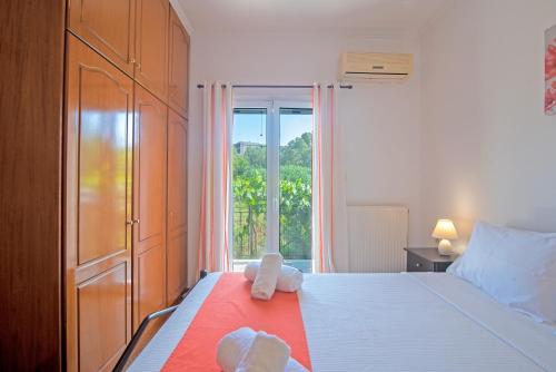a bedroom with a bed with a large window at Kallithea House in Corfu