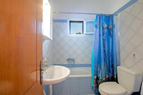 a bathroom with a sink and a toilet and a tub at Kallithea House in Corfu