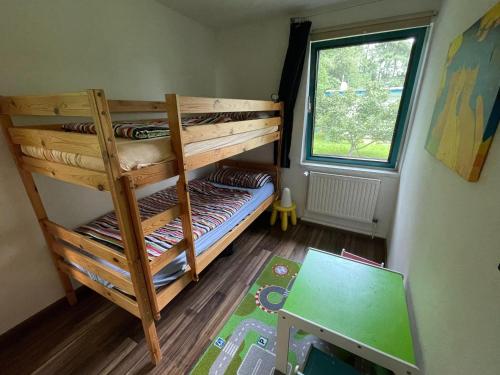 a bunk bed in a room with a window at Blauer Bungalow am See mit Boot in Klein Labenz