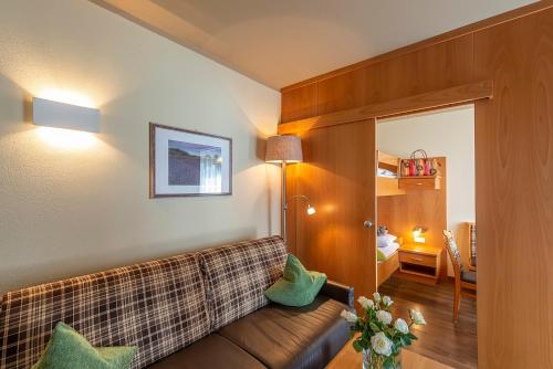 a living room with a couch and a bedroom at Alpenhof Lodge Hirzer in Saltusio