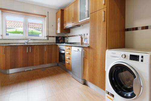 a kitchen with a washer and a washing machine at Vivenda Sol e Mar in Gafanha da Nazaré