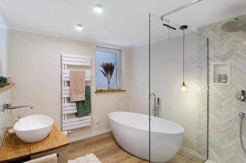 a bathroom with a tub and a glass shower at Ferienwohnung Seelenruhig in Wollershausen