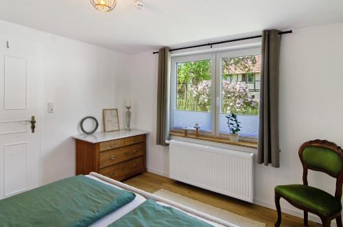a bedroom with a bed and a window and a chair at Ferienwohnung Seelenruhig in Wollershausen