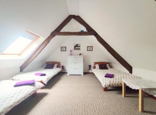 a attic room with two beds and a window at Ensemble De Gites - Pen Ar Voas in Plestin-les-Grèves