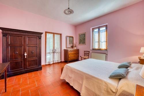 a bedroom with pink walls and a bed and a desk at Appartamento Villa Marta in Spoleto