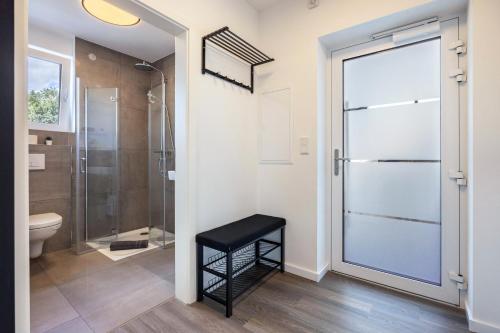a bathroom with a shower and a stool next to a glass door at Egge Resort 7d mit Whirpool u Sauna in Altenbeken