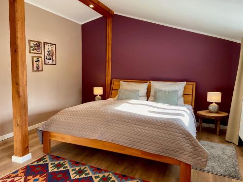 a bedroom with a large bed with a purple wall at Ferienwohnung an der Schlei oben in Fleckeby