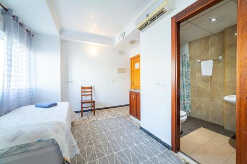a bedroom with a bed and a bathroom with a shower at Hostal Moya in Roquetas de Mar