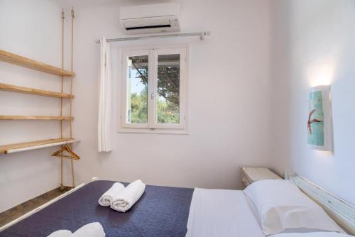 a room with a bed with two towels on it at Green Retreats 1 Paros in Isterni