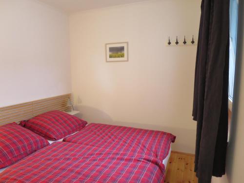 a bedroom with two red beds in a room at Strandhaus am Oberuckersee in Warnitz
