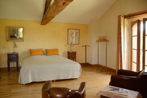 a bedroom with a white bed with orange pillows at Chant du Buc, le Loft in Marssac-sur-Tarn