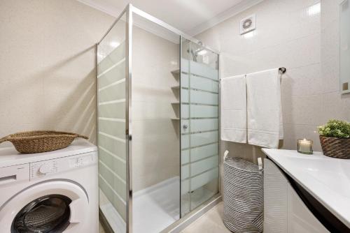a bathroom with a washing machine and a sink at Casa Farol in Portimão