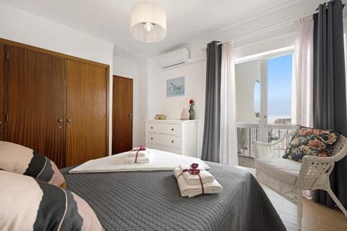 a bedroom with a bed with two towels on it at Casa Farol in Portimão