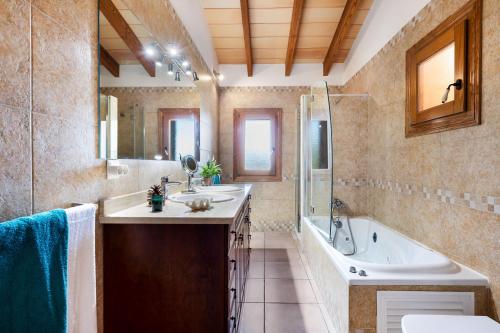 a bathroom with a tub and a sink and a tub and a bath tub at Can Mirló in Marratxí 
