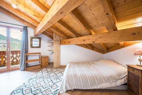a bedroom with a large bed and a wooden ceiling at Chalet Marmotte in Saint-Martin-de-Belleville