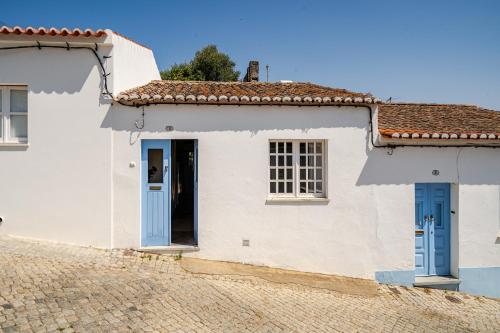 a white house with blue doors at Casa Da Guia in Beja