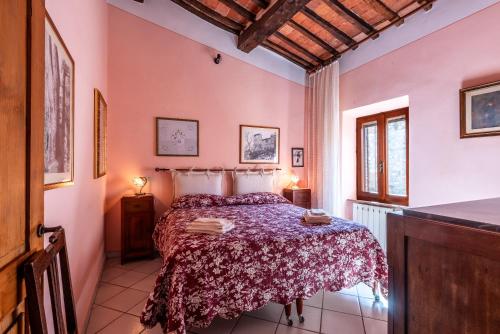 a bedroom with a bed in a room with pink walls at Oasi del borgo Montefollonico in Montefollonico