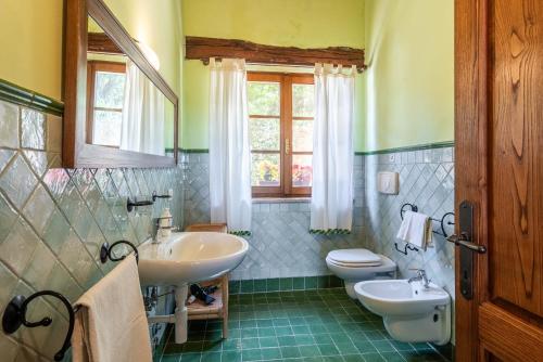 a bathroom with two sinks and a toilet and a window at Agriturismo Paugnano in Radicondoli