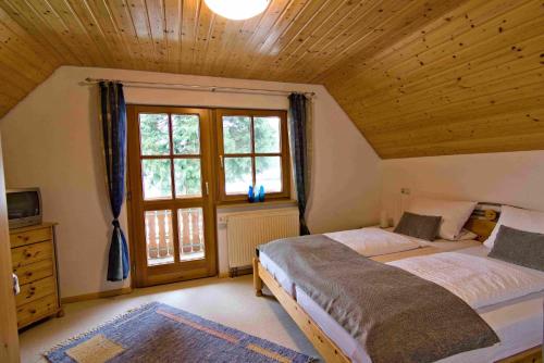 a bedroom with two beds and a large window at Kempfenhof in Seelbach