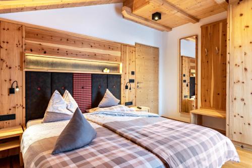 a large bed in a room with wooden walls at Hatzes App Langkofel in Laion