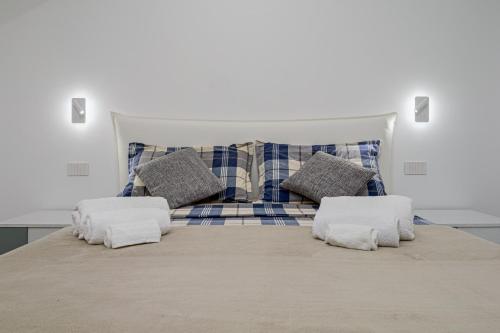 a large bed with two pillows on top of it at Pascoli Suite - by And Service in Golfo Aranci