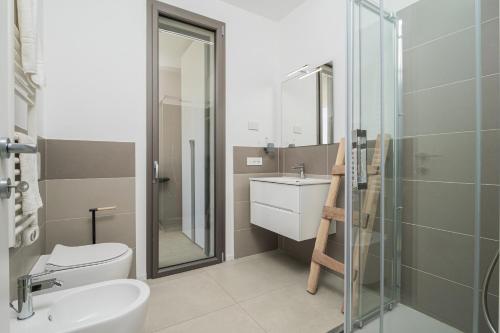 a bathroom with a toilet and a sink and a shower at Pascoli Suite - by And Service in Golfo Aranci