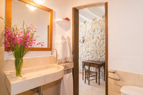 a bathroom with a sink and a vase of flowers at Finca Rafal in Son Servera